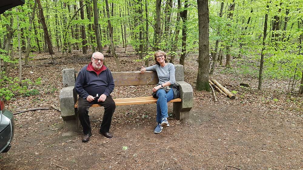 Theo Ehlen und Gaby Körner sitzen auf der neuen Bank im Wald
