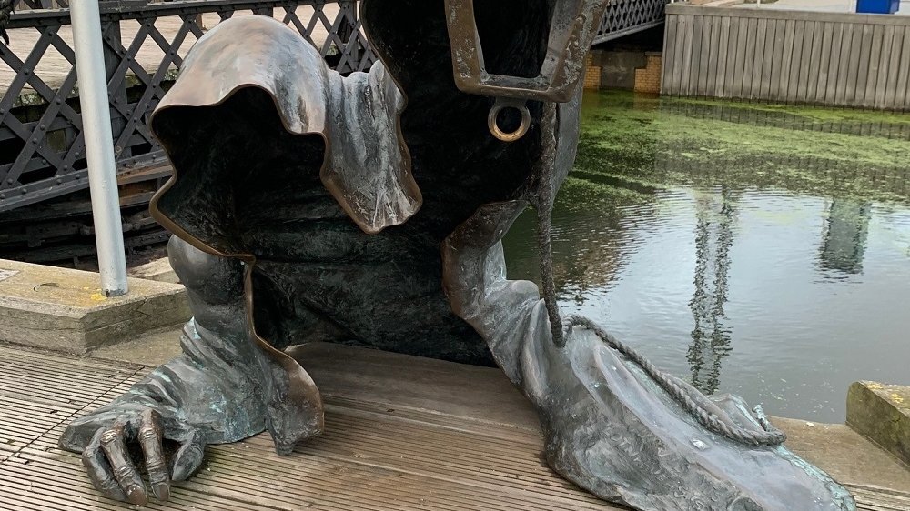 Skulptur "Der Tod" steigt aus einem Fluss ans Ufer