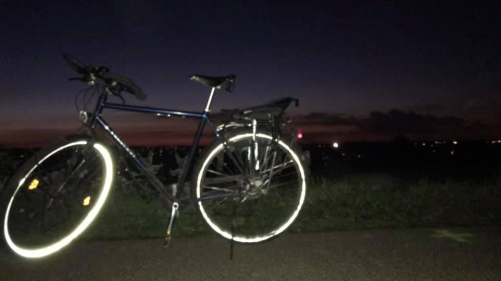 Abgestelltes Fahrrad mit reflektierenden Reifen bei Nacht