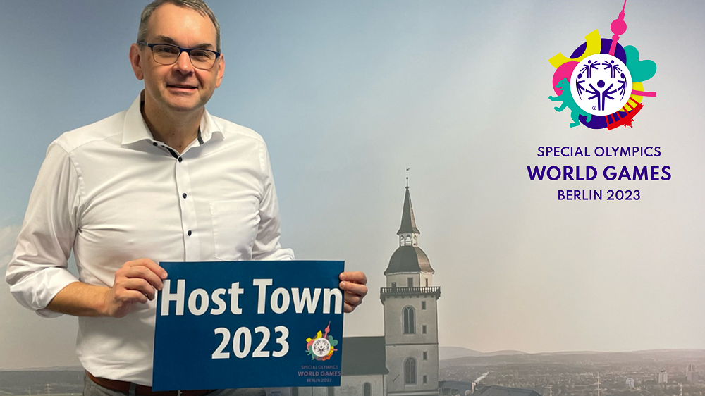Bürgermeister Stefan Rosemann mit einem Schild "Host Town 2023"