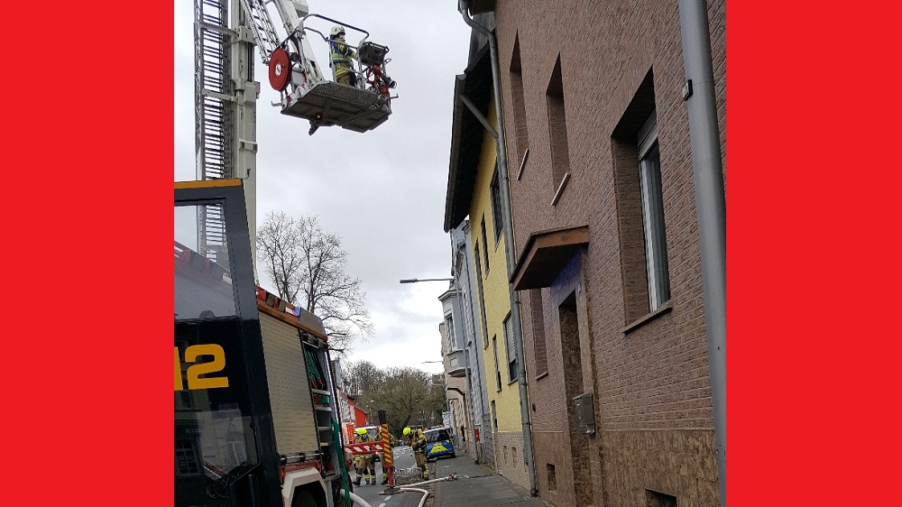 Kranwagen der Feuerwehr an einem Haus