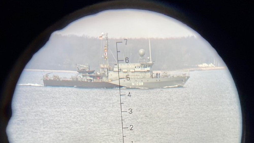 Blick durch ein Fernglas auf das Patenboot "Siegburg" in der Kieler Förde