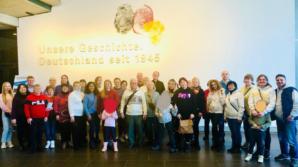 Gruppenfoto vor dem Schriftzug "Unsere Geschichte. Deutschland seit 1945"