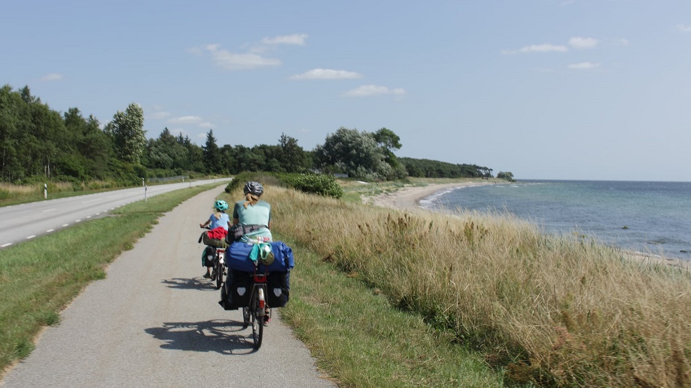 Radfahrer auf einem Radweg direkt am Meer.