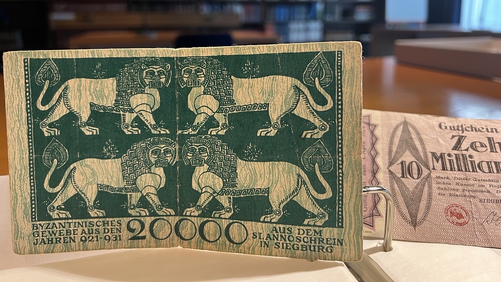 Zwei Notgeldscheine, der über 20.000 Mark zeigt einen Ausschnitt des Löwentuchs.