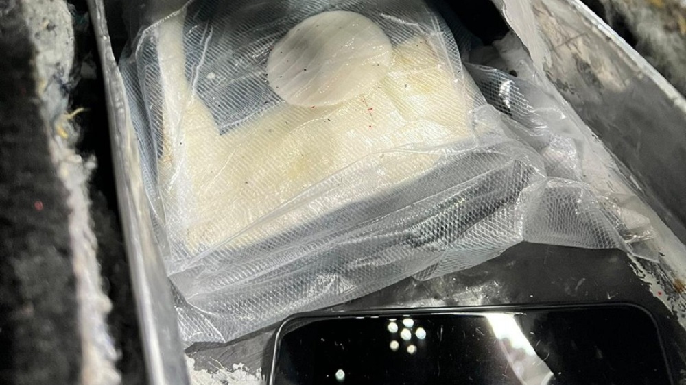 Kokainziegel und Smartphone im geöffneten Drogenversteck.